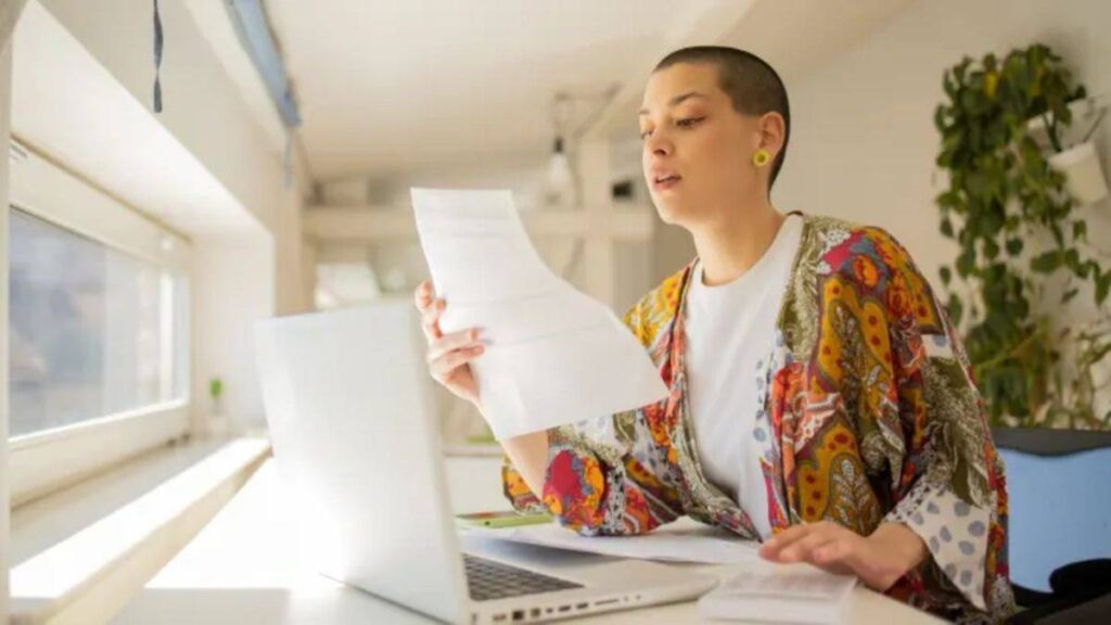 A young adult reading a paper document