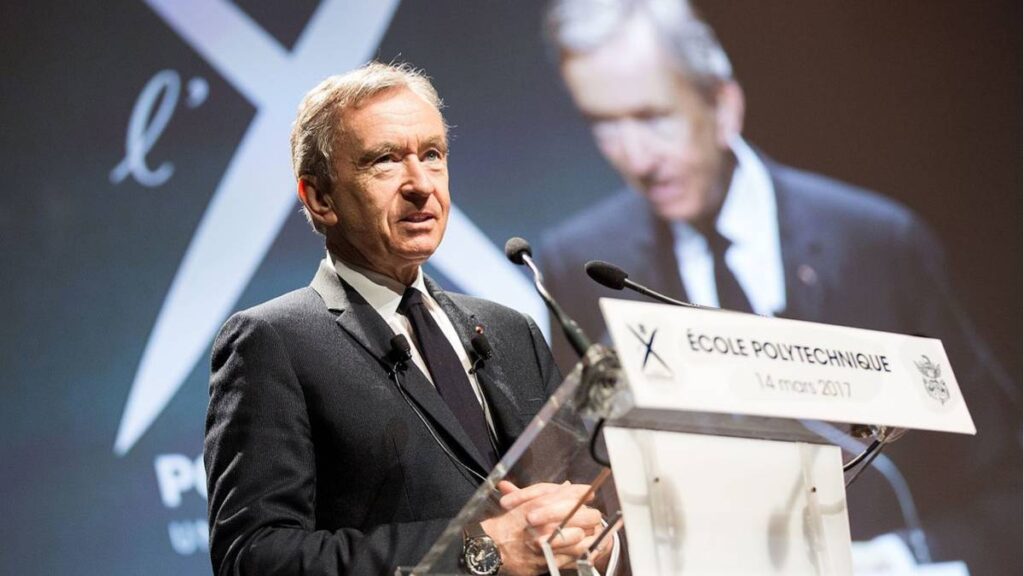 Arnault addressing a gathering at his alma mater