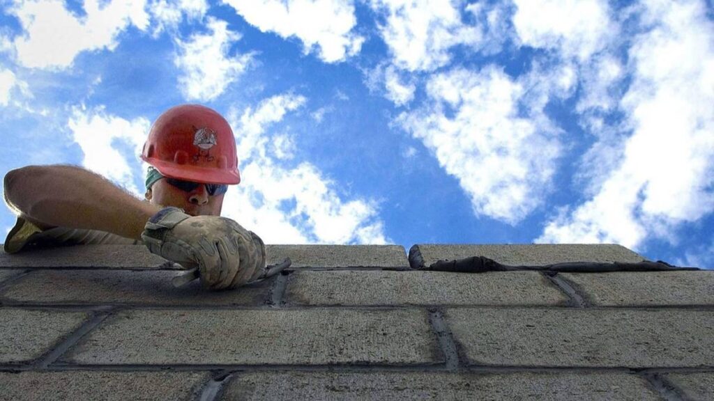 A man building a concrete wall