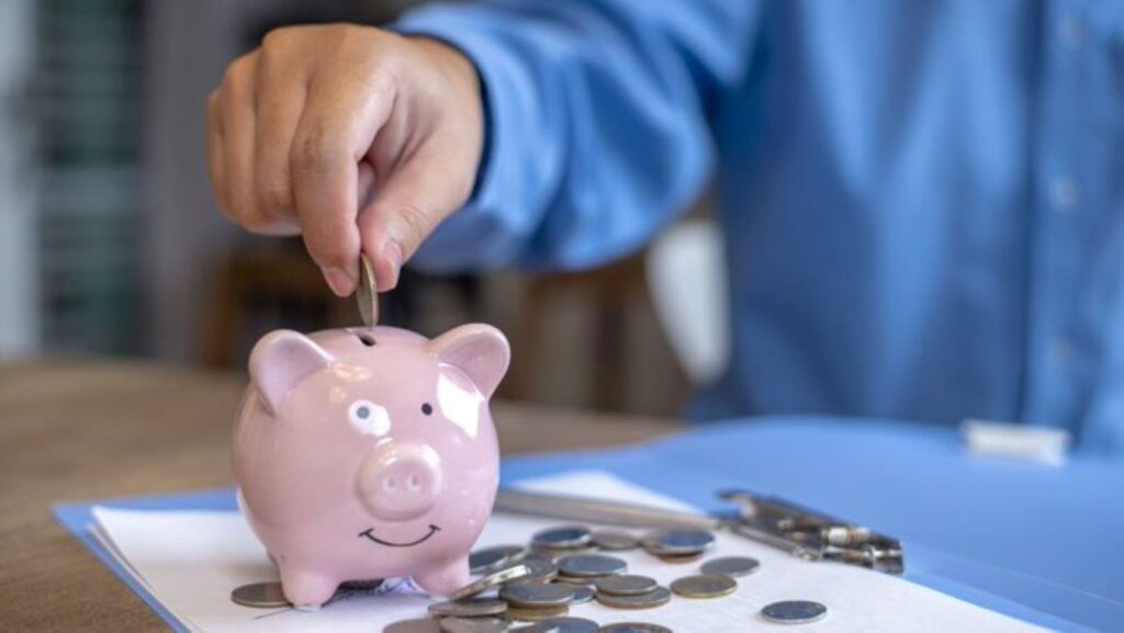 Dropping quarters into a piggy bank