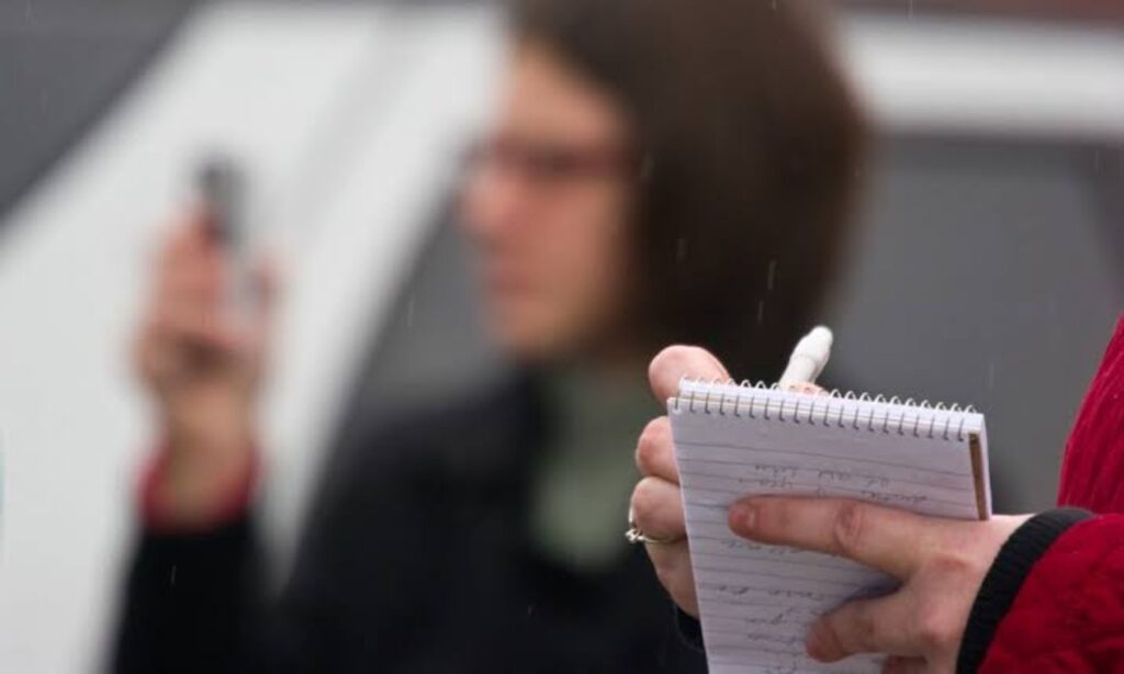 A journalist scribbling on a notepad