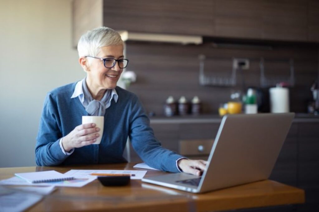 A woman working on a PC in her kitchen