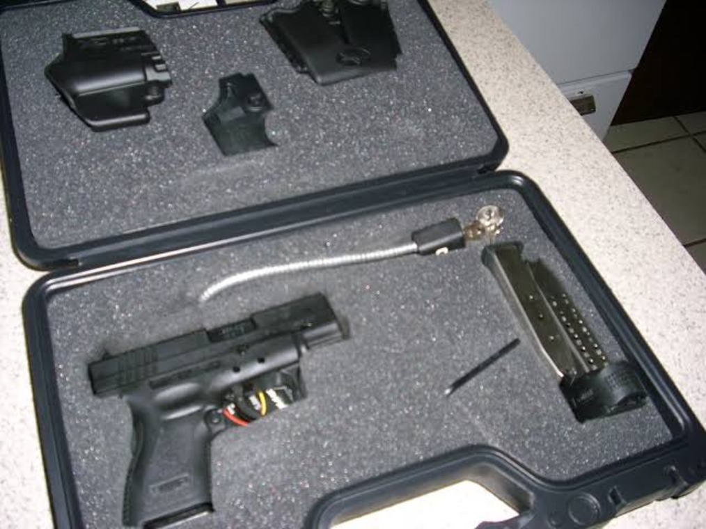 A pistol and its accessories in a case