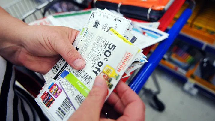 A woman sorts through coupons while shopping