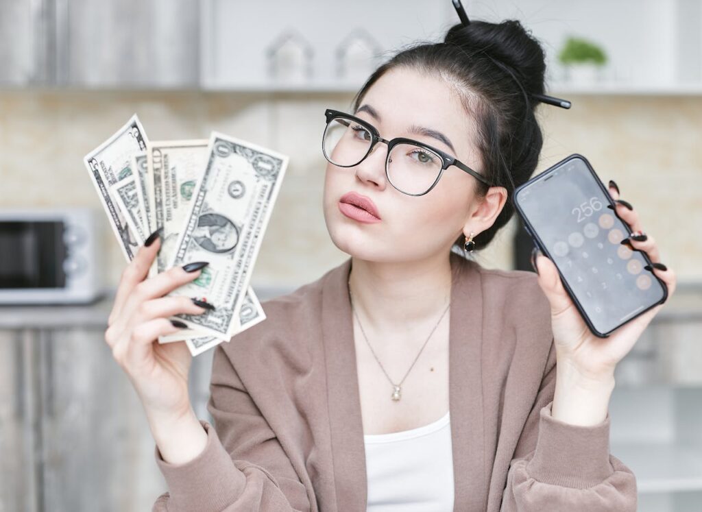 woman holding a smartphone and money