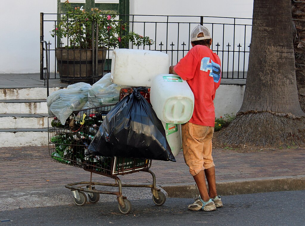 Bergie (homeless person) collecting recyclables outside