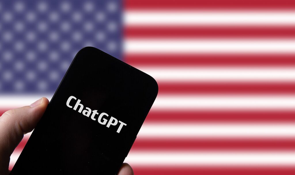 Hand holding smartphone with OpenAI Chat GPT against flag of USA