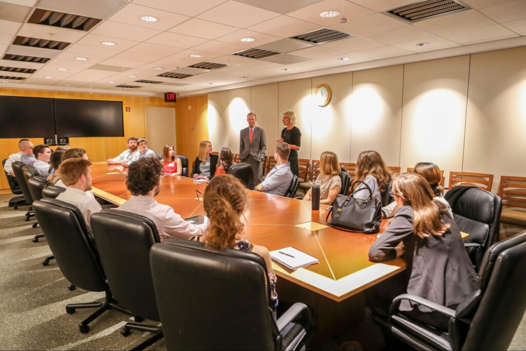 Several people sitting around a large board room table