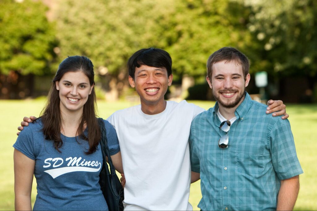 Three students taking a group photograph