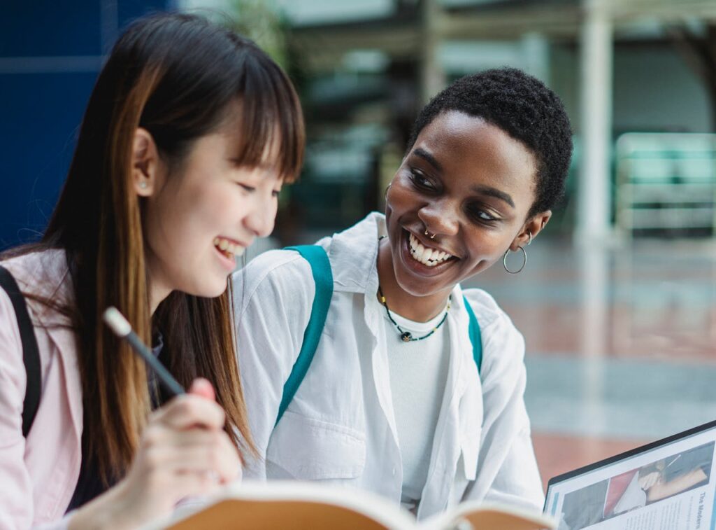 Happy multiracial students studying and talking on street