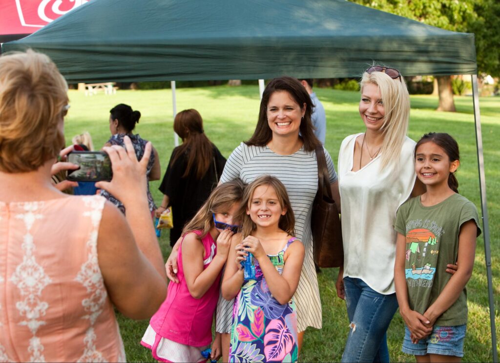 Mother taking a group picture with her daughters