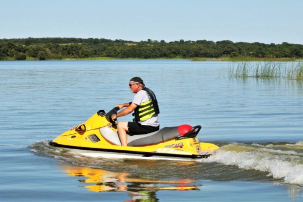 An elderly man jet skiing on a lake