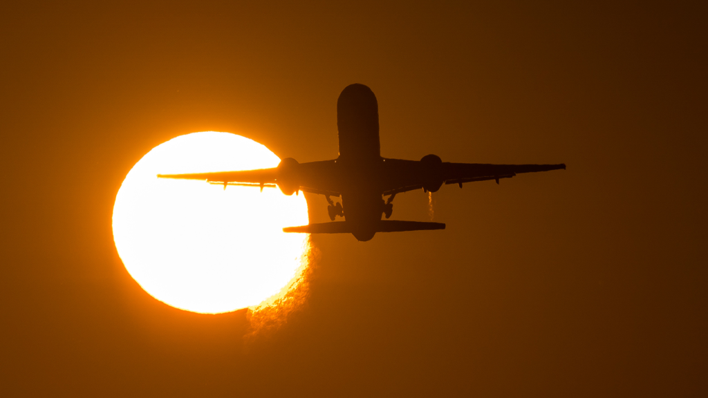 Takeoff of the plane against the background of the solar disk