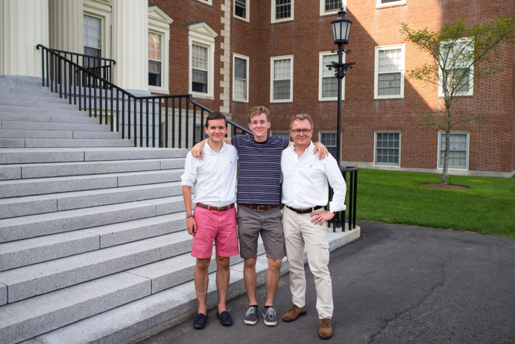 A man and his sons in front of their dorm house