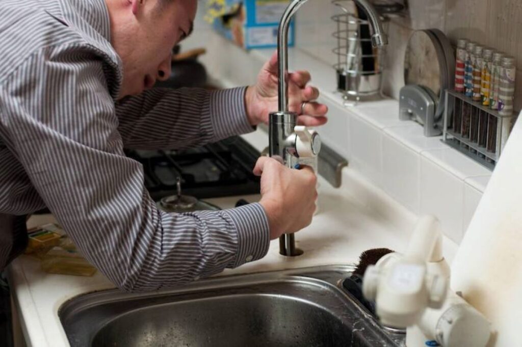 Man fixing a kitchen faucet