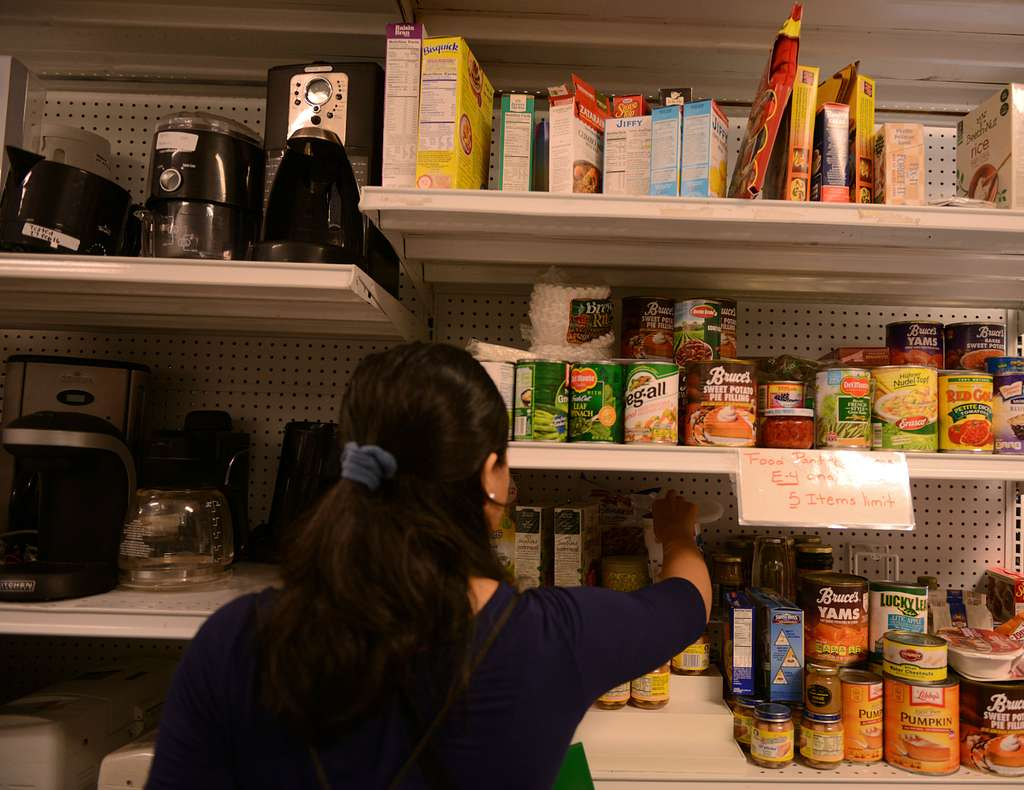 A military spouse picks canned goods being given away