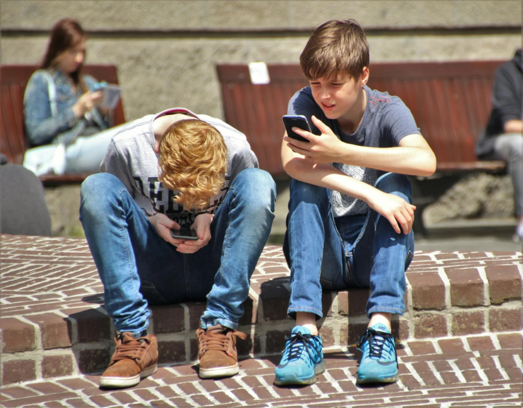 Two teenagers absorbed with their smartphones