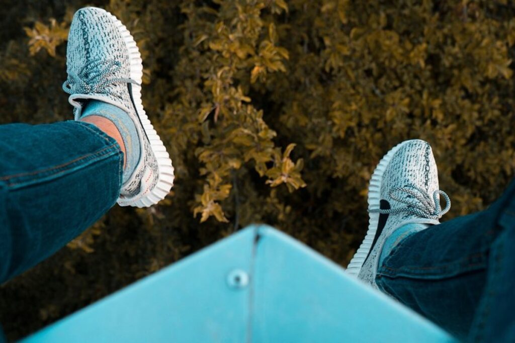 Man swinging from a high point with shoes on