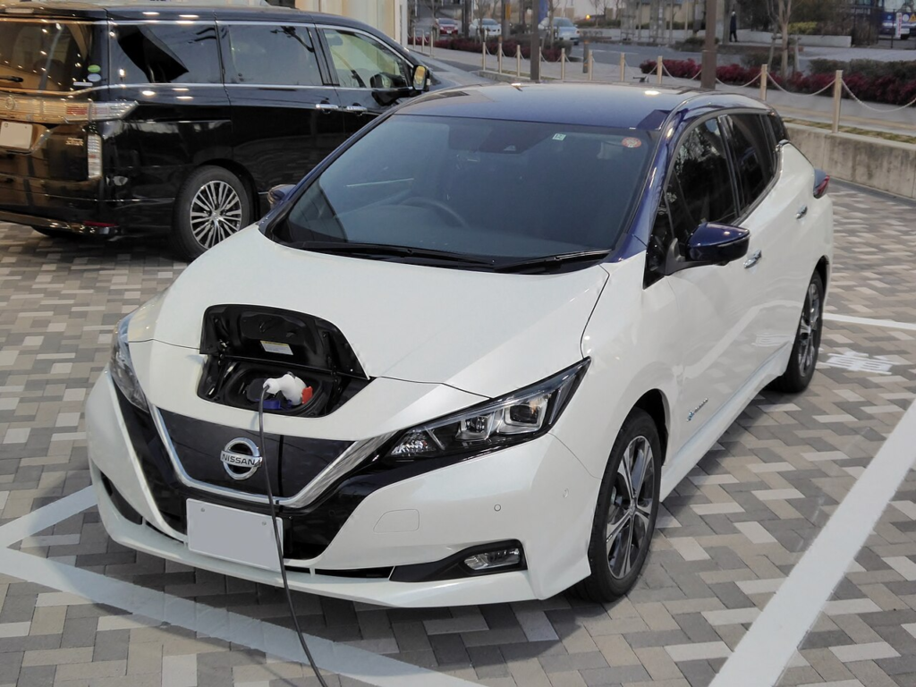 A Nissan Leaf charging in a parking lot