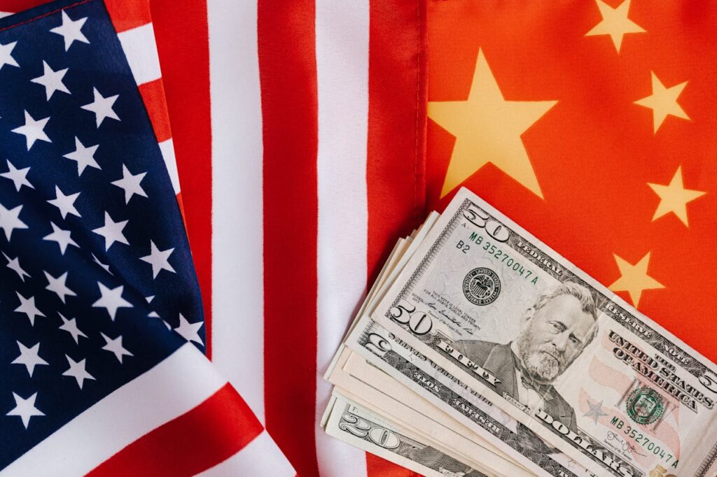 The flags of the US and China with dollar bills lying on
