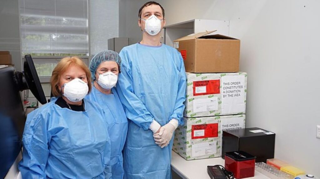 Scientists standing next to boxed laboratory equipment