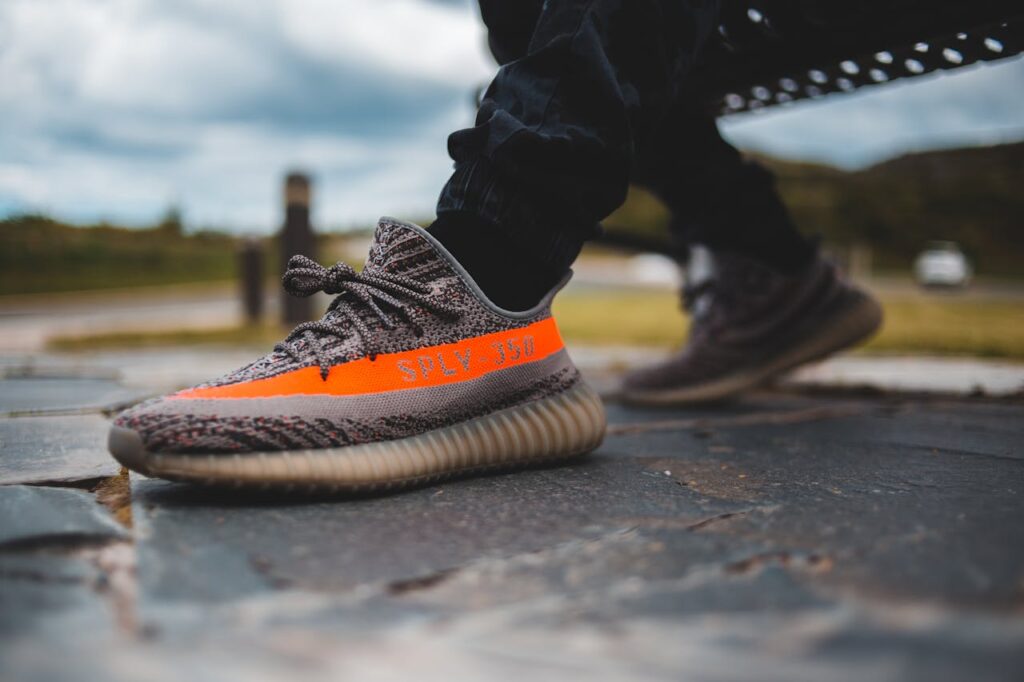 Man in Yeezy shoes sits on a public bench