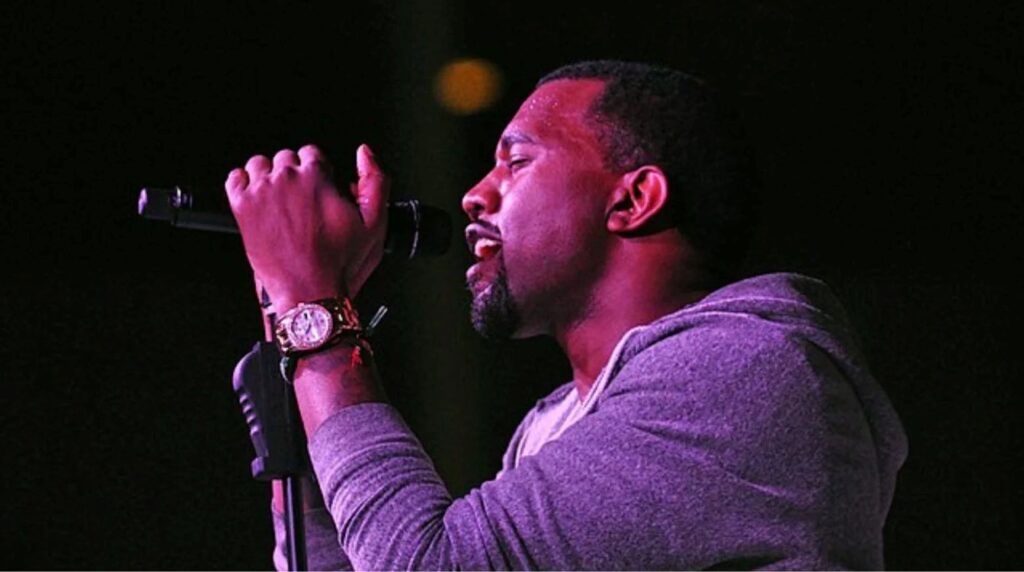 West singing into a stand-up mic