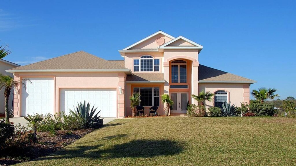 A pink house with a palm tree in front of it