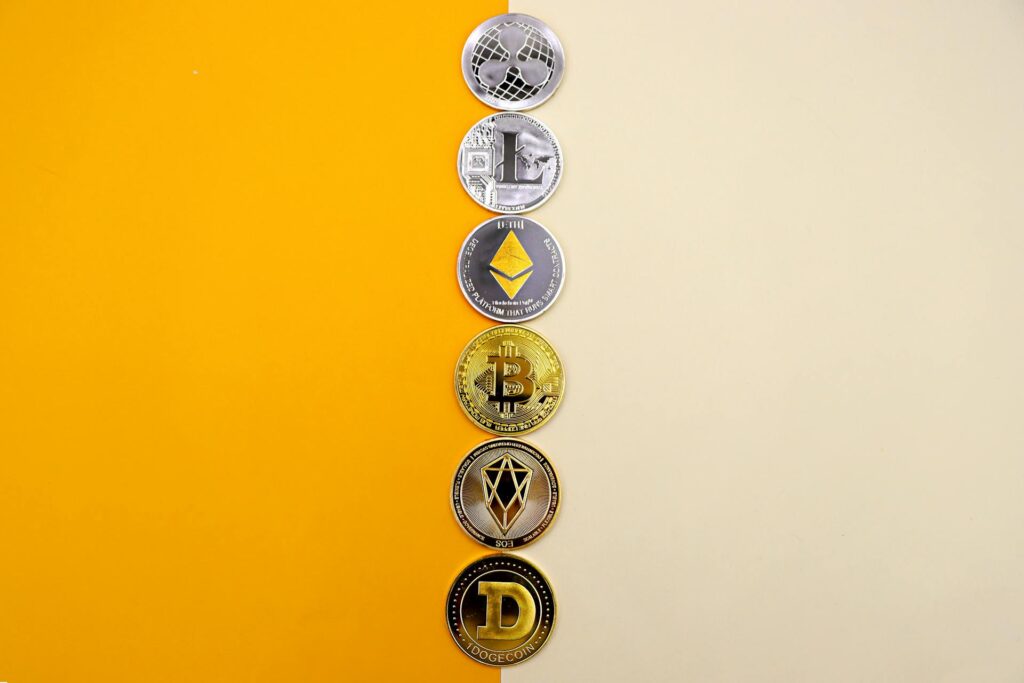 A Line of Cryptocurrency Coins Lying on Yellow and White Background