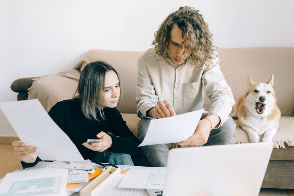 Man and woman holding papers at home