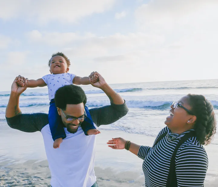 A couple and their baby at the beach