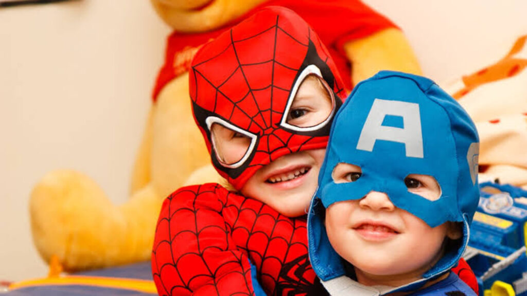 Two kids dorning superhero costumes