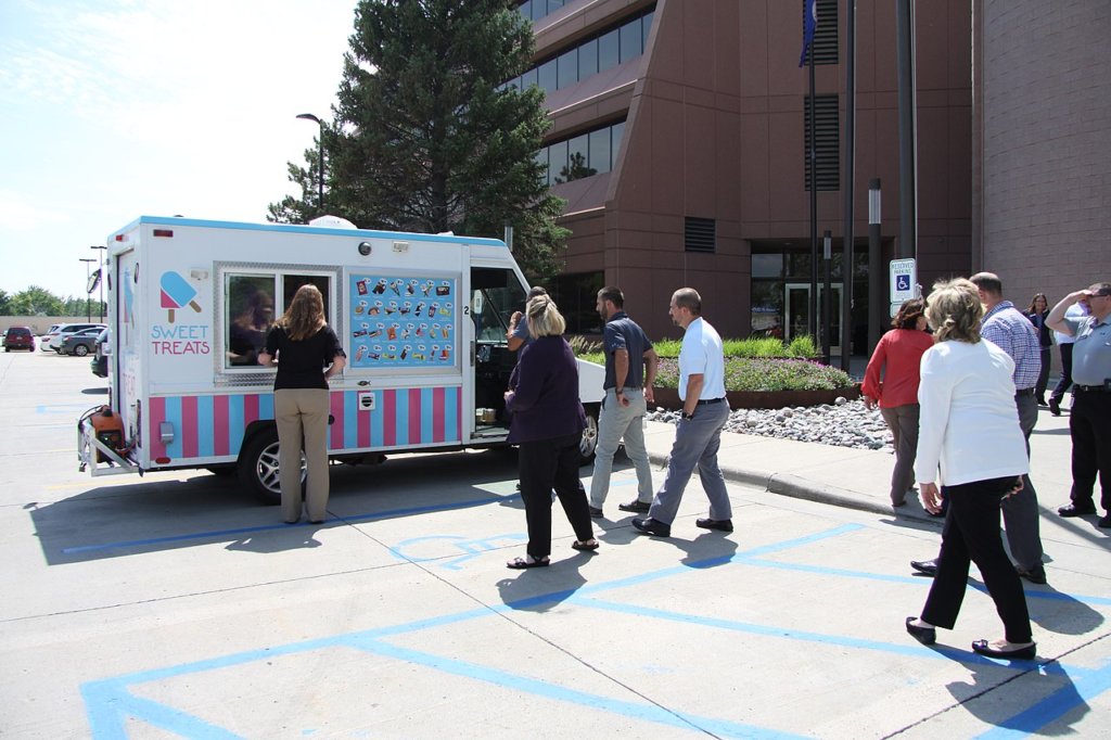 A group of adults around an icecream van