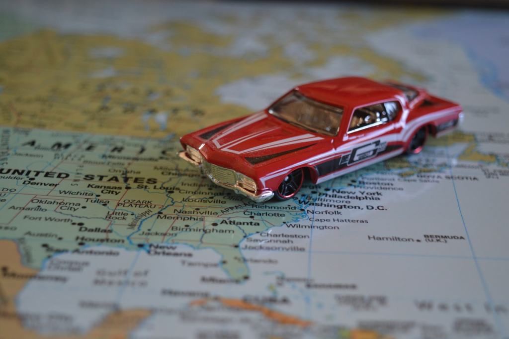 Red model of a vintage car on a map