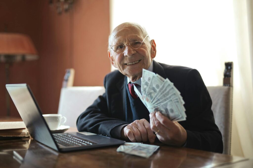 Happy senior businessman holding money in hand