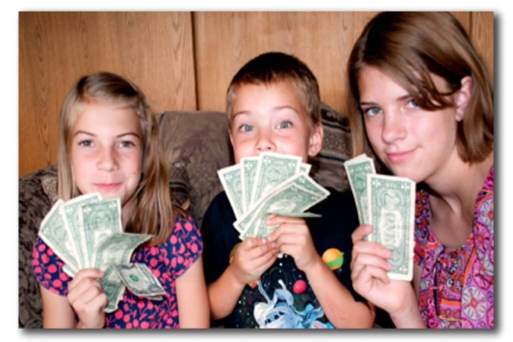 Youngsters holding dollar bills