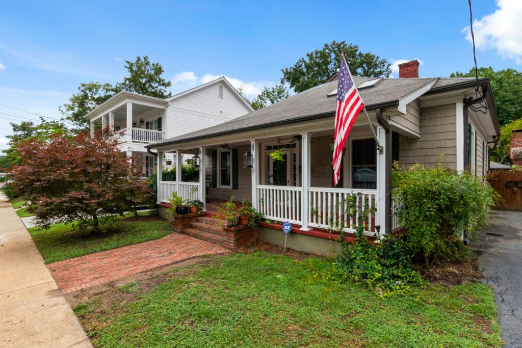 Bungalow with an American flag hanging off the porch