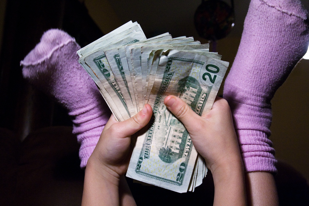 A young child holding $20 bills