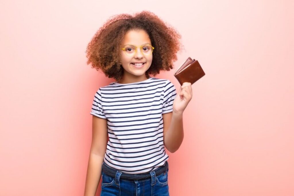 A young girl holding a brown leather wallet