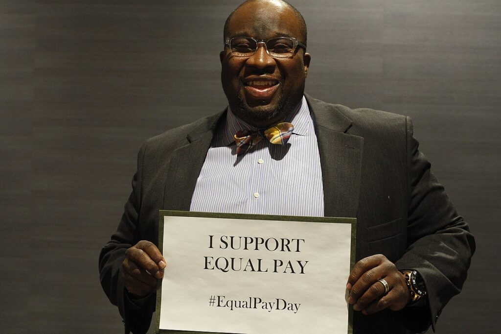 Senator Hayden holding up an equal pay poster