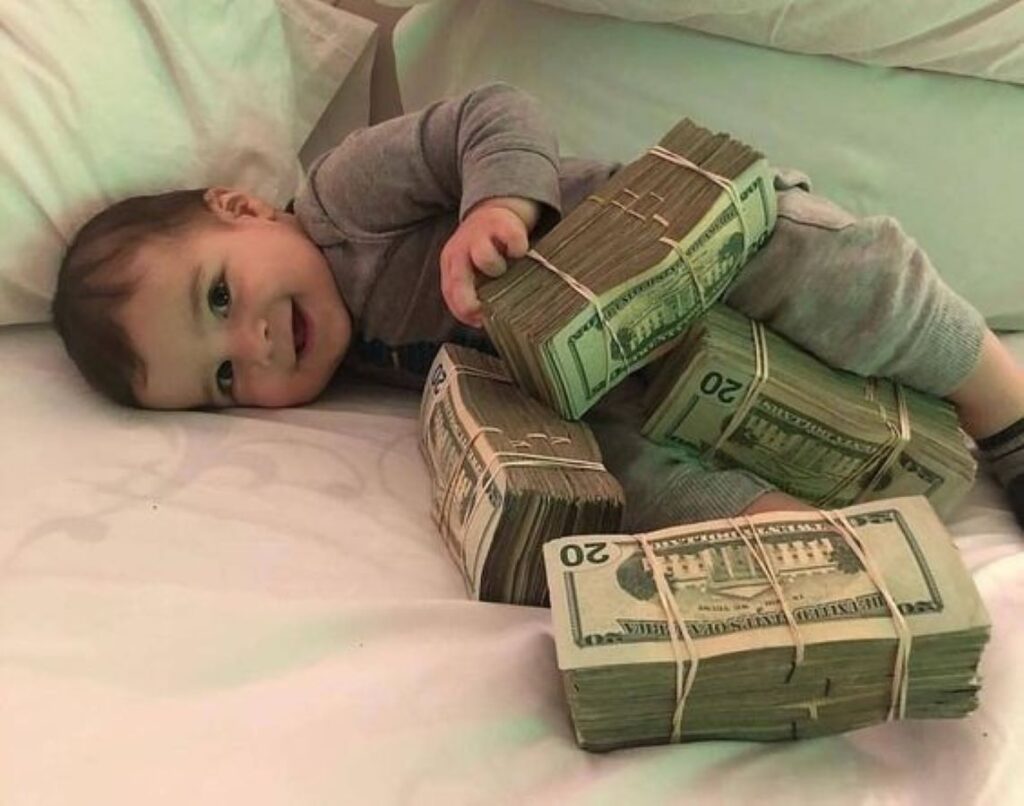 Baby lying next to bales of money