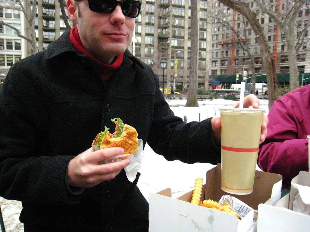 A bloke eating some hamburger and chips