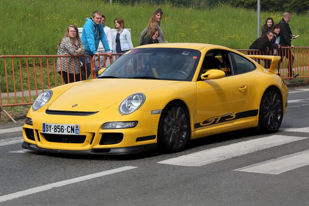 Spectators staring at a yellow sports car