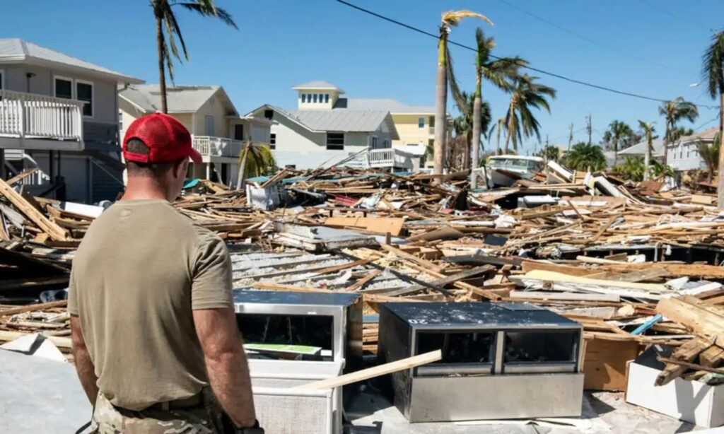 Man taking in the aftermath of a hurricane