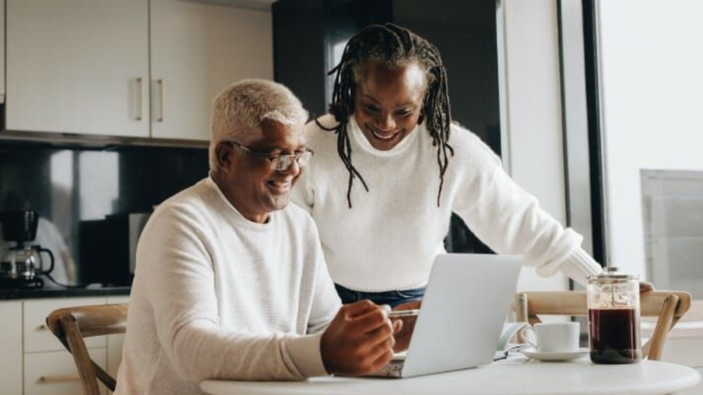 Elderly couple smiling at laptop