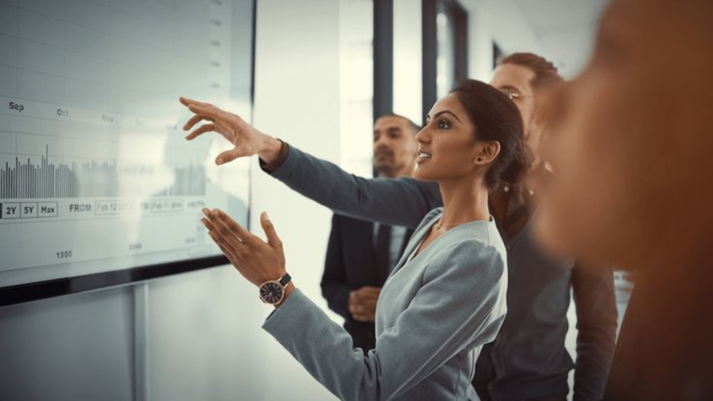 Staff reviewing business data on large screen