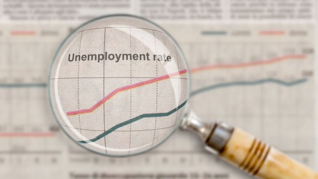 A magnifier over a paper showing "Unemployment Rate"