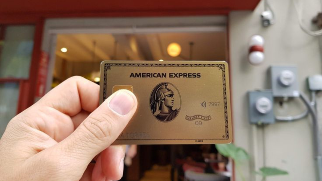 Holding a gold American Express credit card