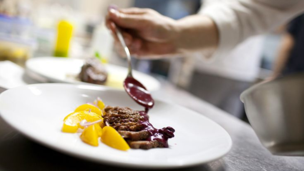 A restaurant chef plating a meal