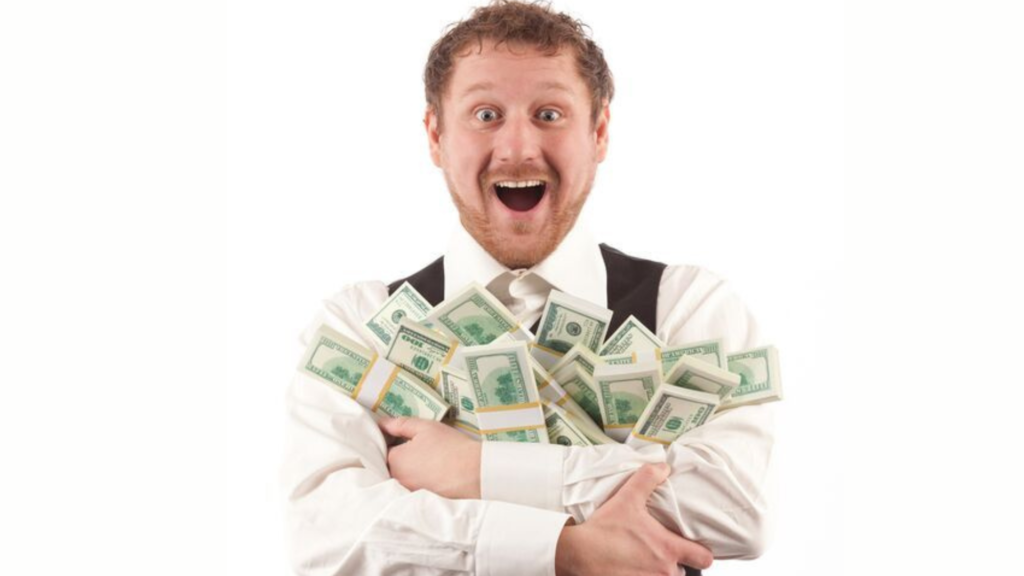 A man holding bundles of cash to his chest